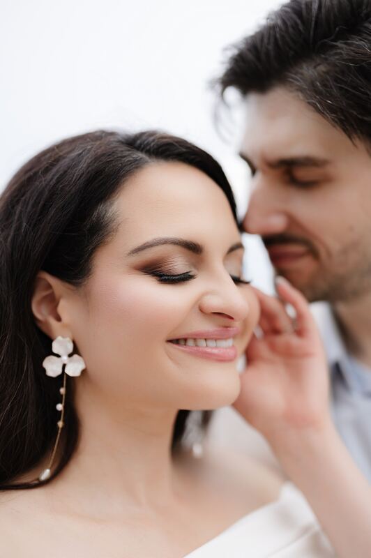 Iviani beaming beside Joey, her floral earring catching the light