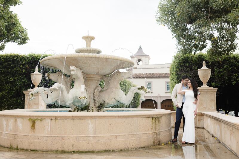 Iviani and Joey beside a grand stone fountain
