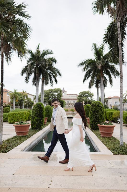 Iviani and Joey walking hand in hand along the pool&rsquo;s edge